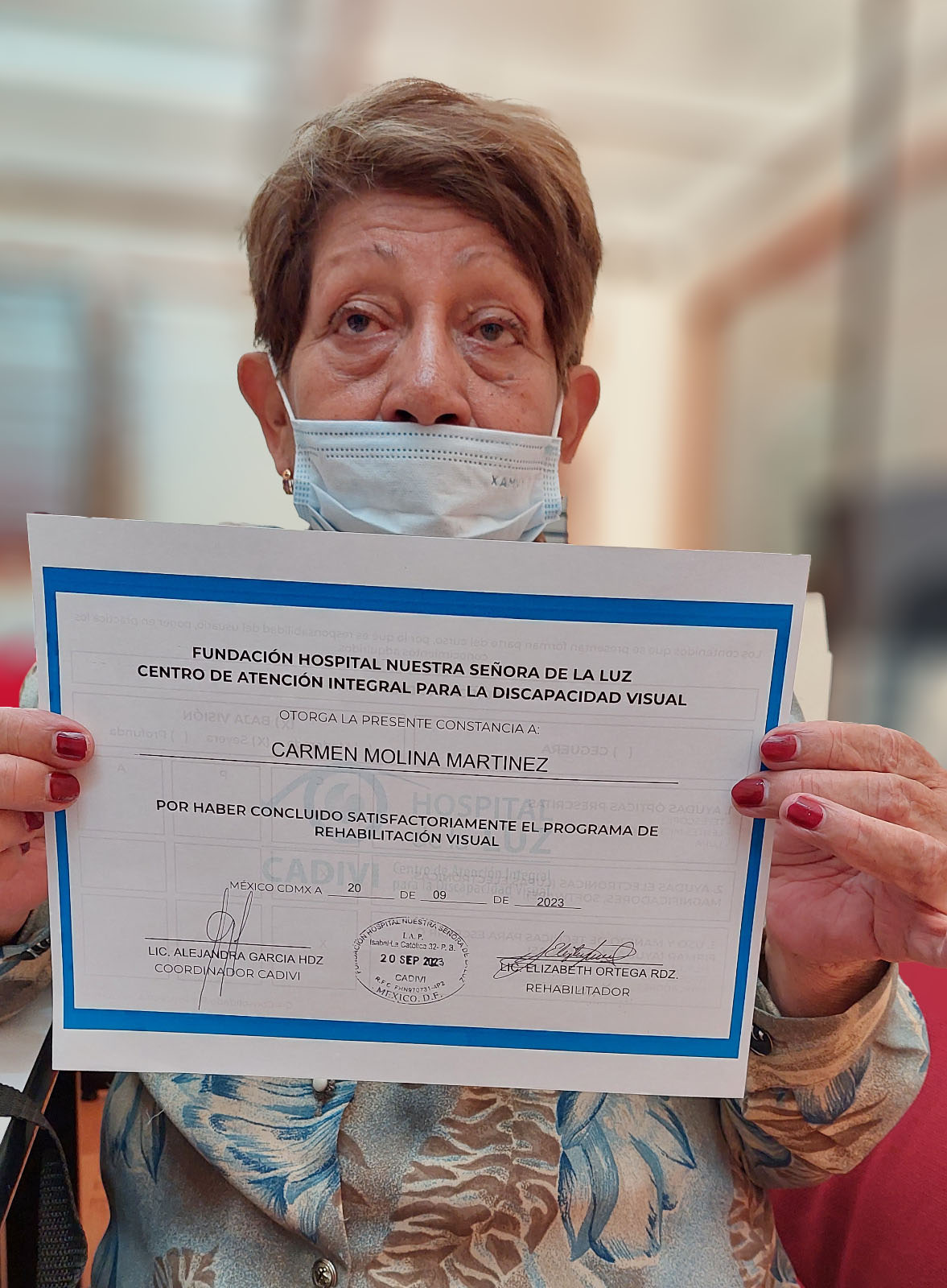 mujer sosteniendo un reconocimiento frente a la cámara