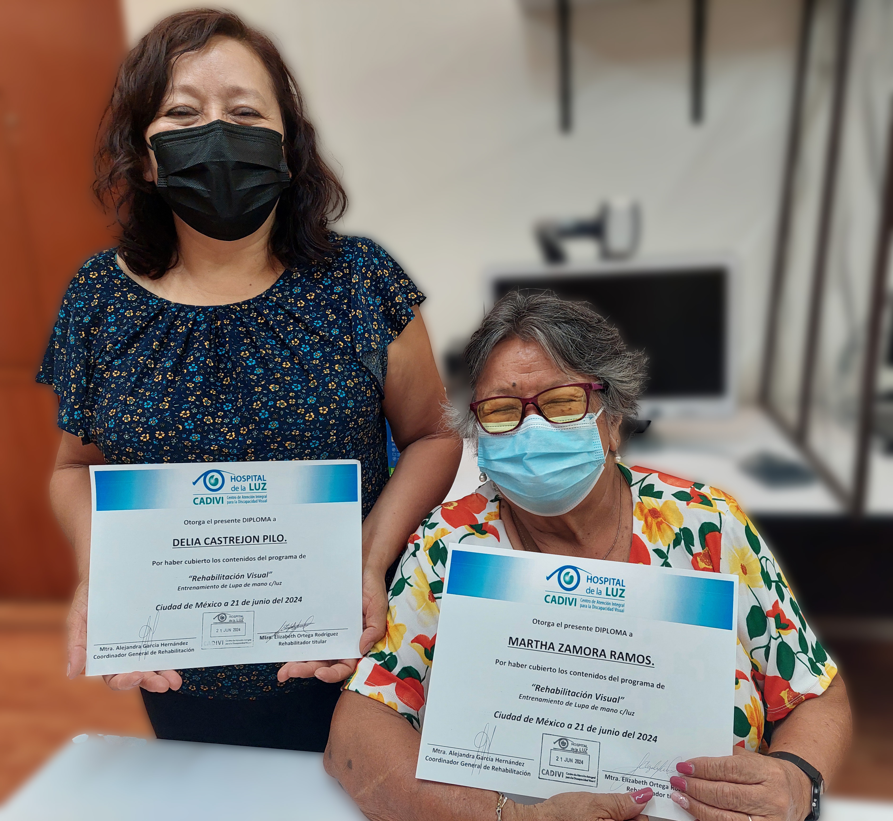 Señora con su hijo sosteniendo un reconocimiento frente a la cámara