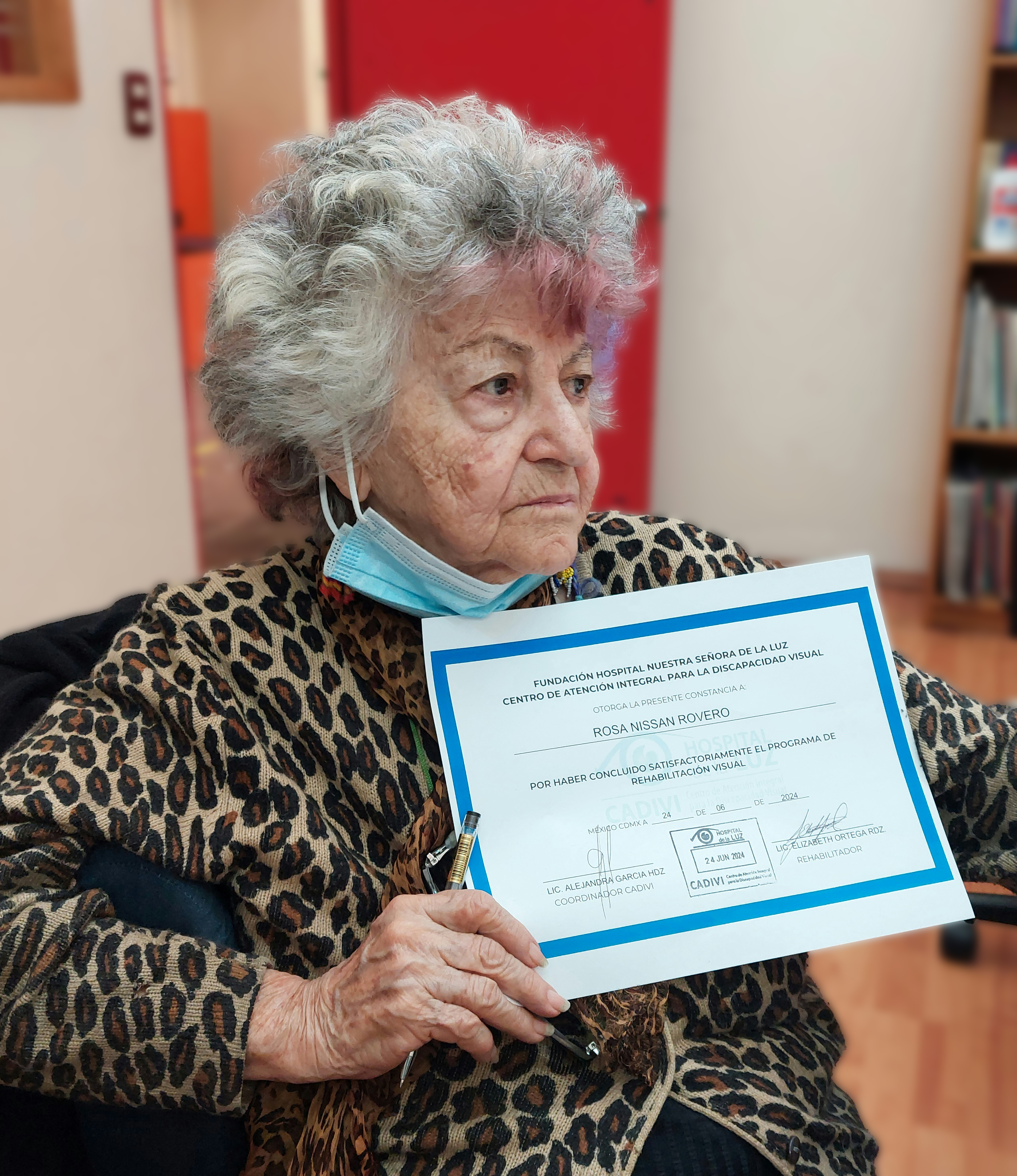 Señora con su hijo sosteniendo un reconocimiento frente a la cámara